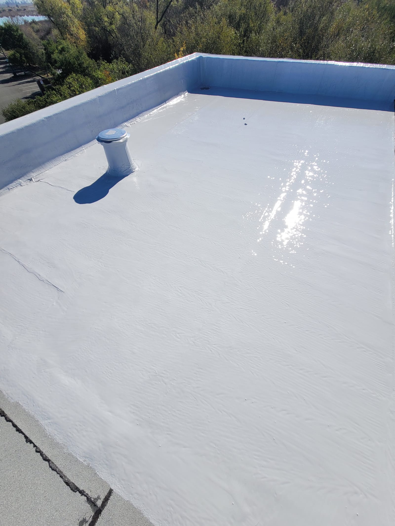 Commercial flat roof silicone application — warehouse facility — Patterson, CA